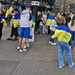 Menschen mit blau-gelben Fahnen am Hauptbahnhof