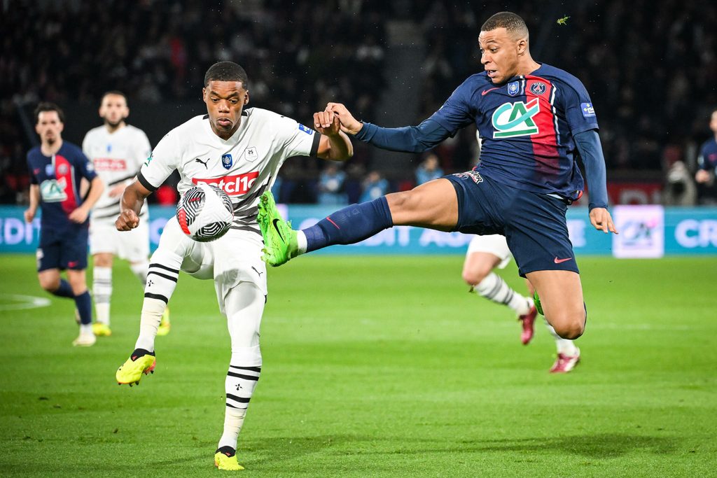 Warmed Omari und Kylian Mbappé strecken ihre Füße in Richtung Ball