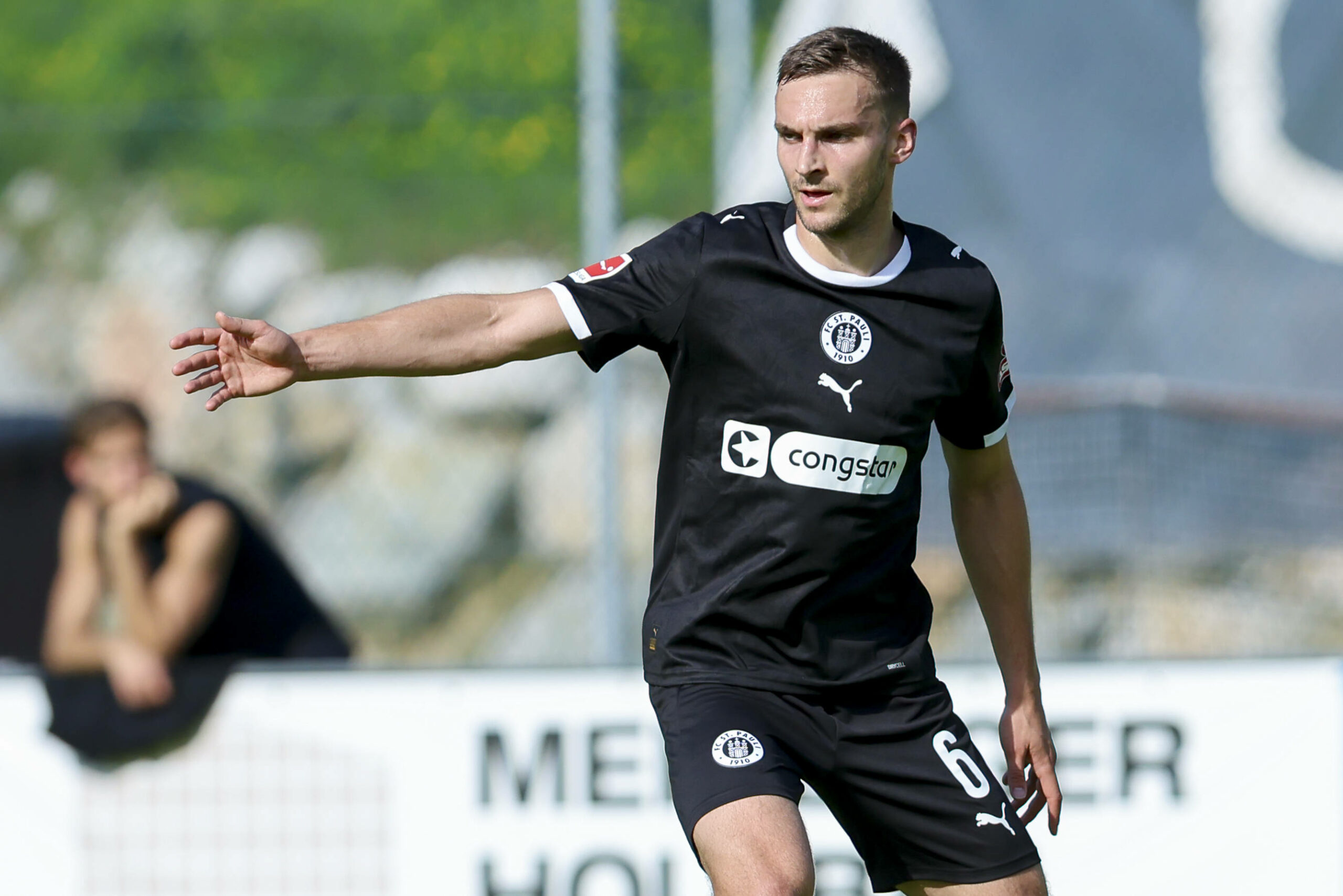 James Sands zeigt mit seinem rechten Arm