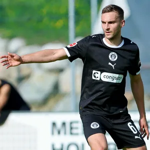 James Sands zeigt mit seinem rechten Arm