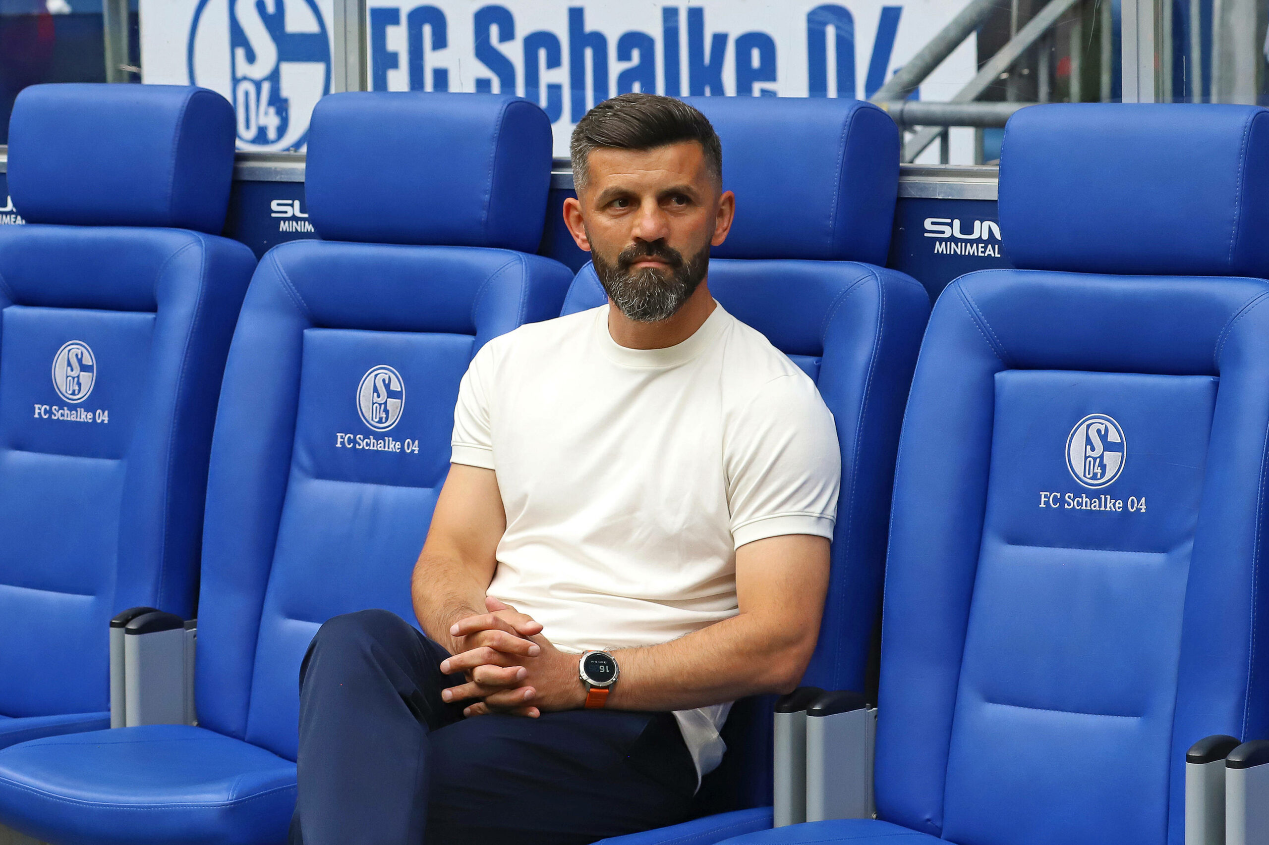 Miron Muslic sitzt mit gefalteten Händen auf der Schalke-Bank.