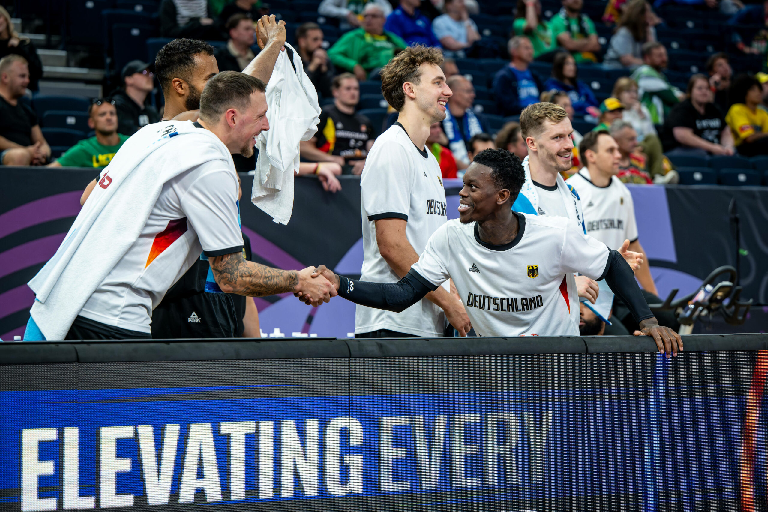Daniel Theis reicht Dennis Schröder lachend die Hand