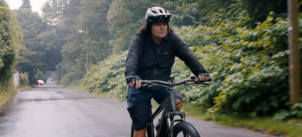 Frontmann Mille Petrozza fährt Fahrrad.