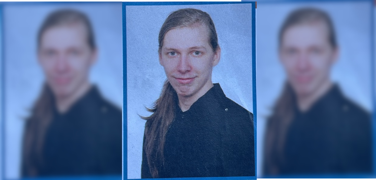 Ein junger Mann mit langem blonden Zopf