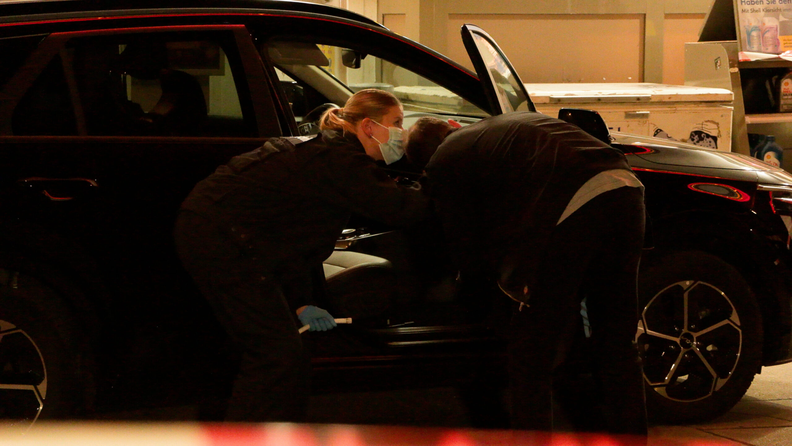 Beamte untersuchen das zivile Polizeiauto, aus dem die Waffe gestohlen wurde.