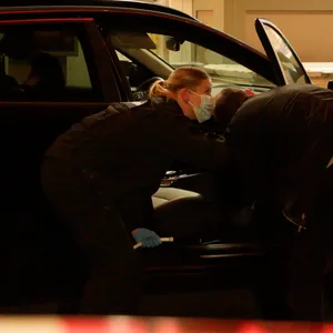 Beamte untersuchen das zivile Polizeiauto, aus dem die Waffe gestohlen wurde.
