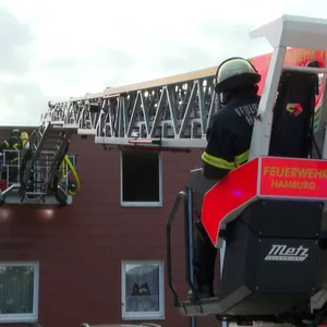 Feuerwehr an einem verqualmten Fenster