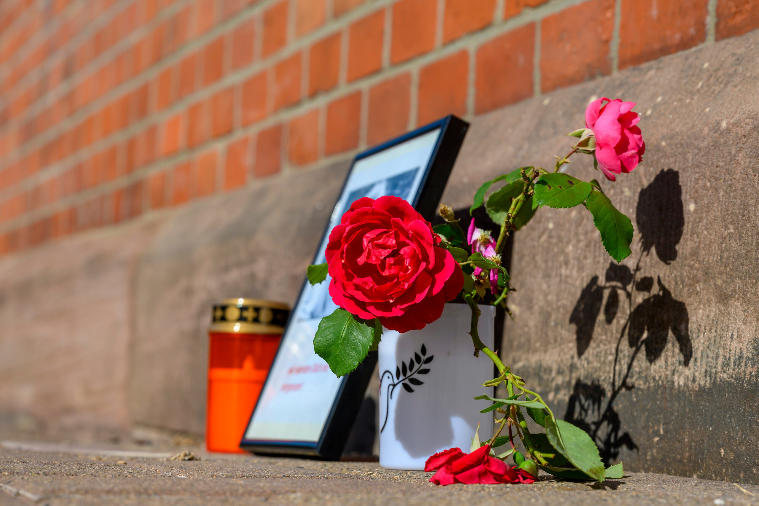 Blumen und Kerzen stehen an einem Bahngebäude. Nach dem Tod einer 16-Jährigen am Bahnhof Friedland sitzt ein Mann per Unterbringungsbefehl in einer psychiatrischen Klinik.