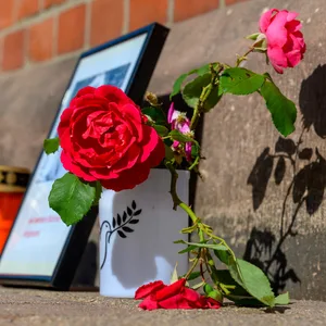Blumen und Kerzen stehen an einem Bahngebäude. Nach dem Tod einer 16-Jährigen am Bahnhof Friedland sitzt ein Mann per Unterbringungsbefehl in einer psychiatrischen Klinik.
