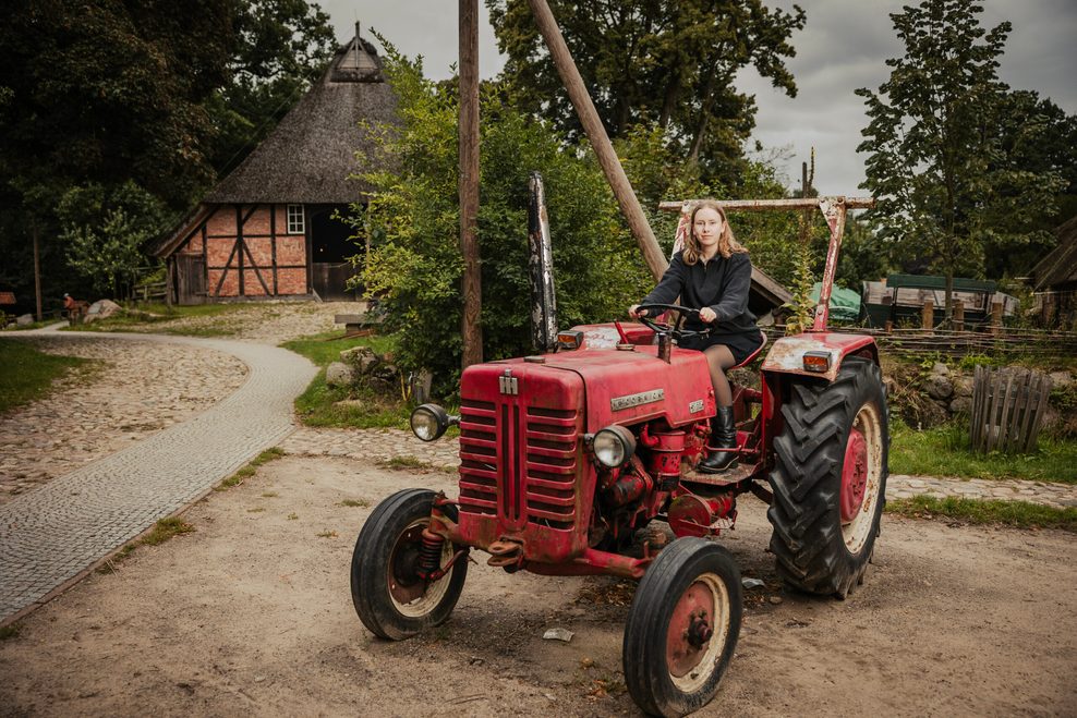 MOPO Reporterin Emilia Skibbe sitzt auf einem roten Traktor.