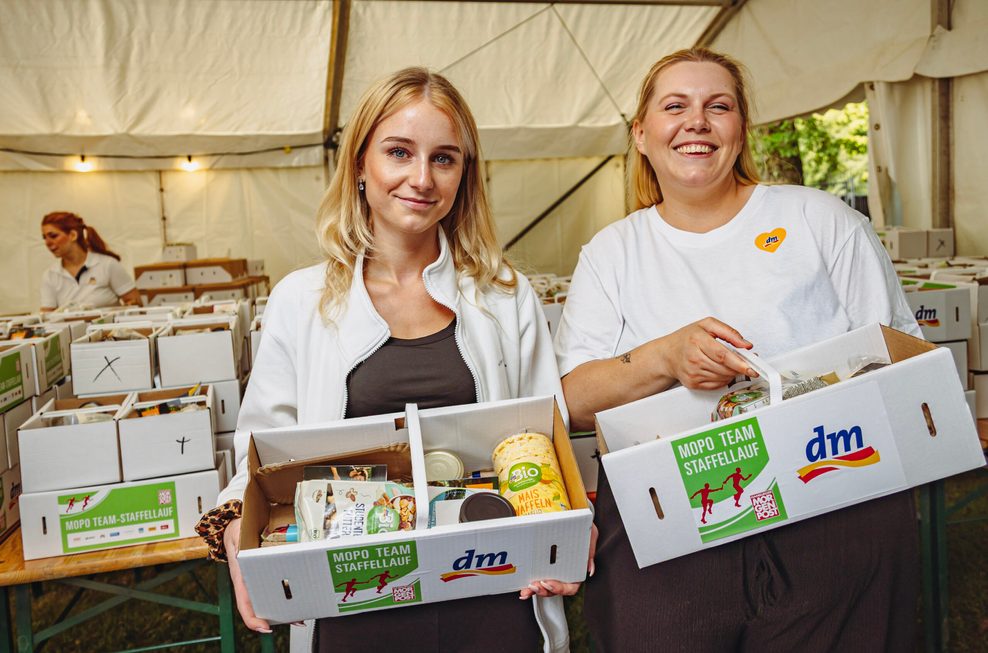 Kaya (l., 22) und Annika (35) verteilen die Picknick-Körbe.