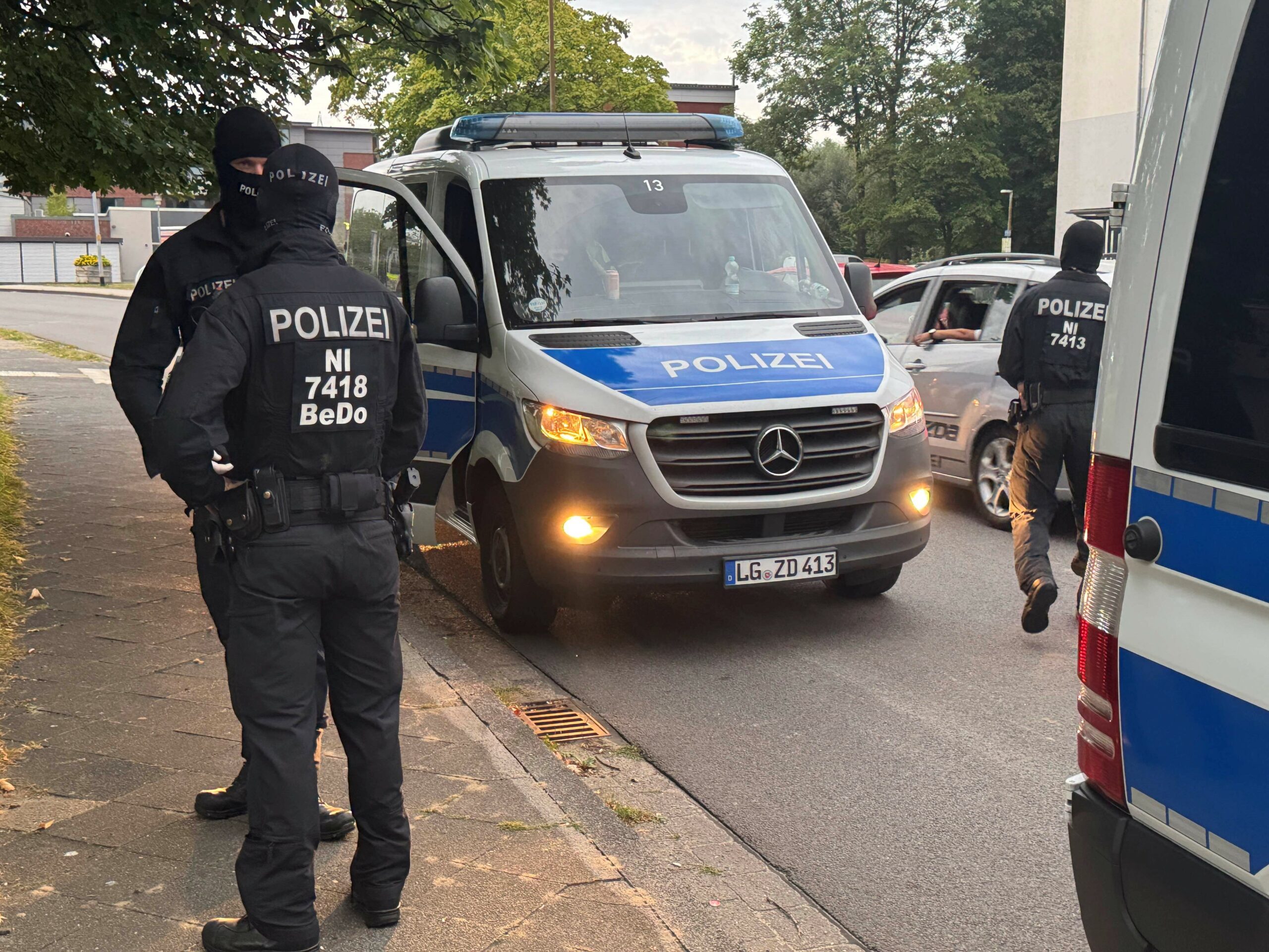 Polizisten vor einem Haus