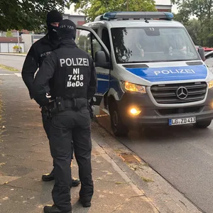 Polizisten vor einem Haus