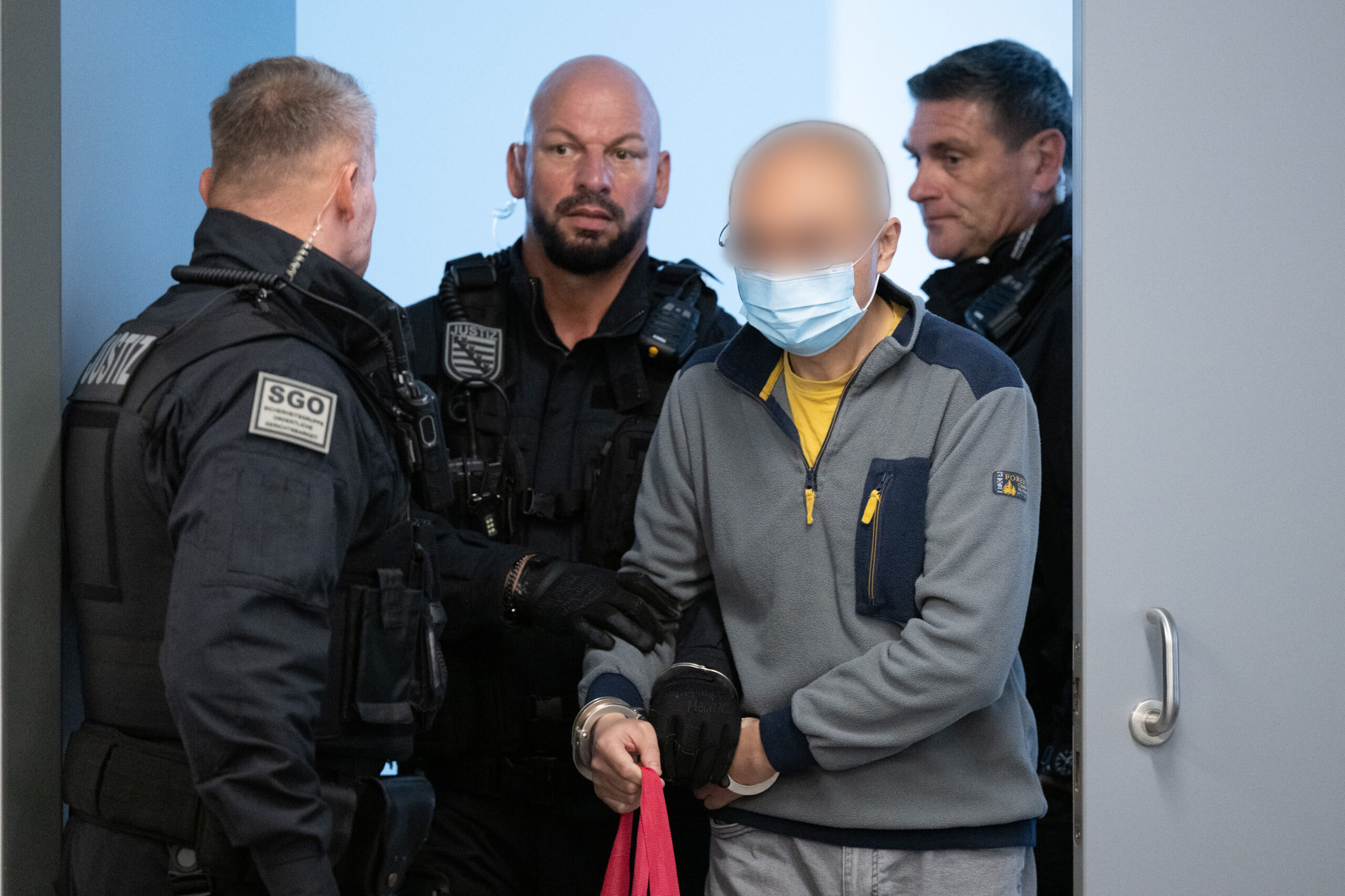 Polizisten halten Angeklagten fest