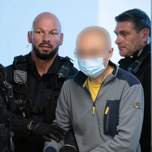 Polizisten halten Angeklagten fest