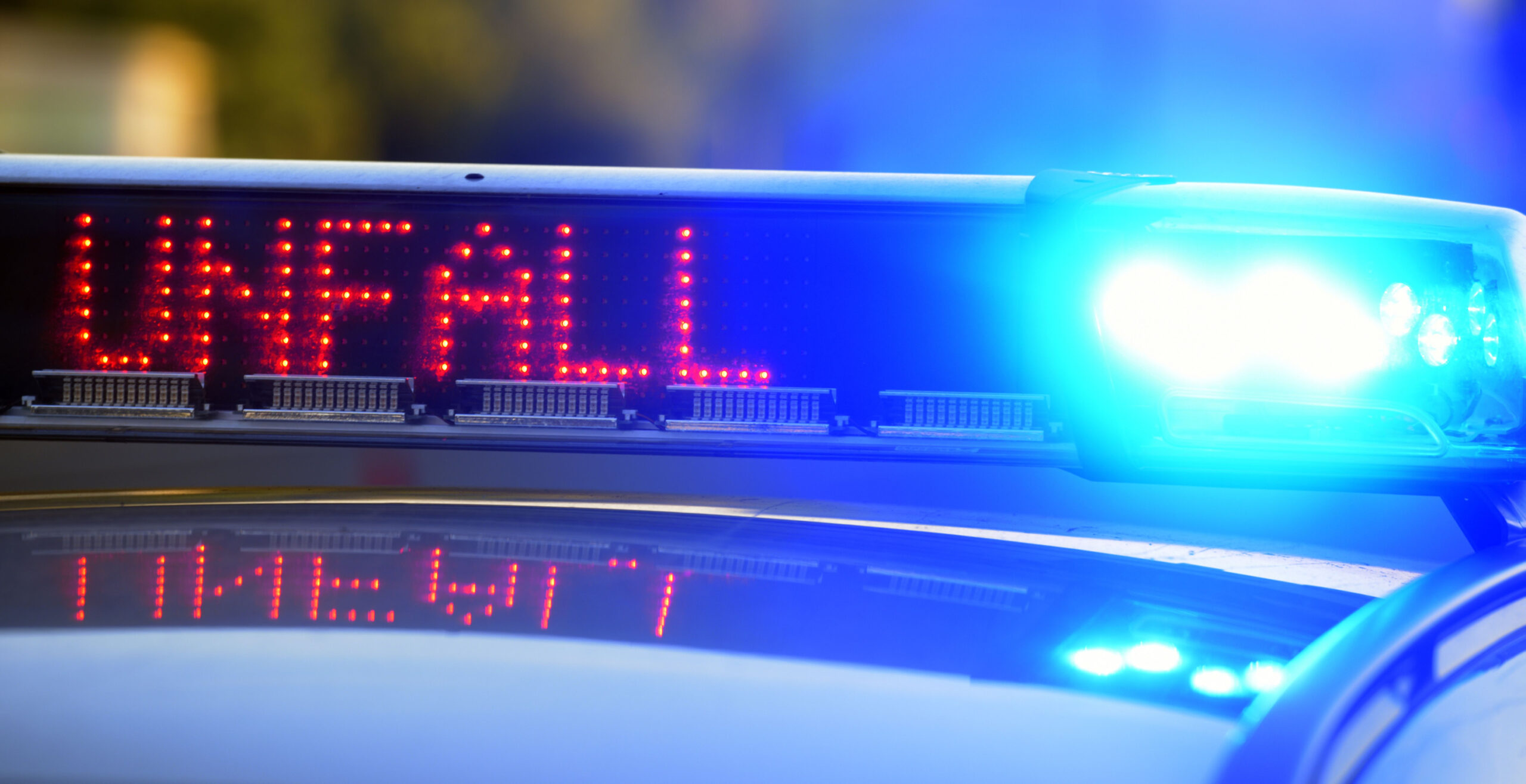 Auf einem Polizeifahrzeug warnt eine Leuchtschrift vor einer Unfallstelle