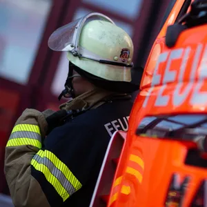 Ein Feuerwehrmann neben einem Feuerwehrauto