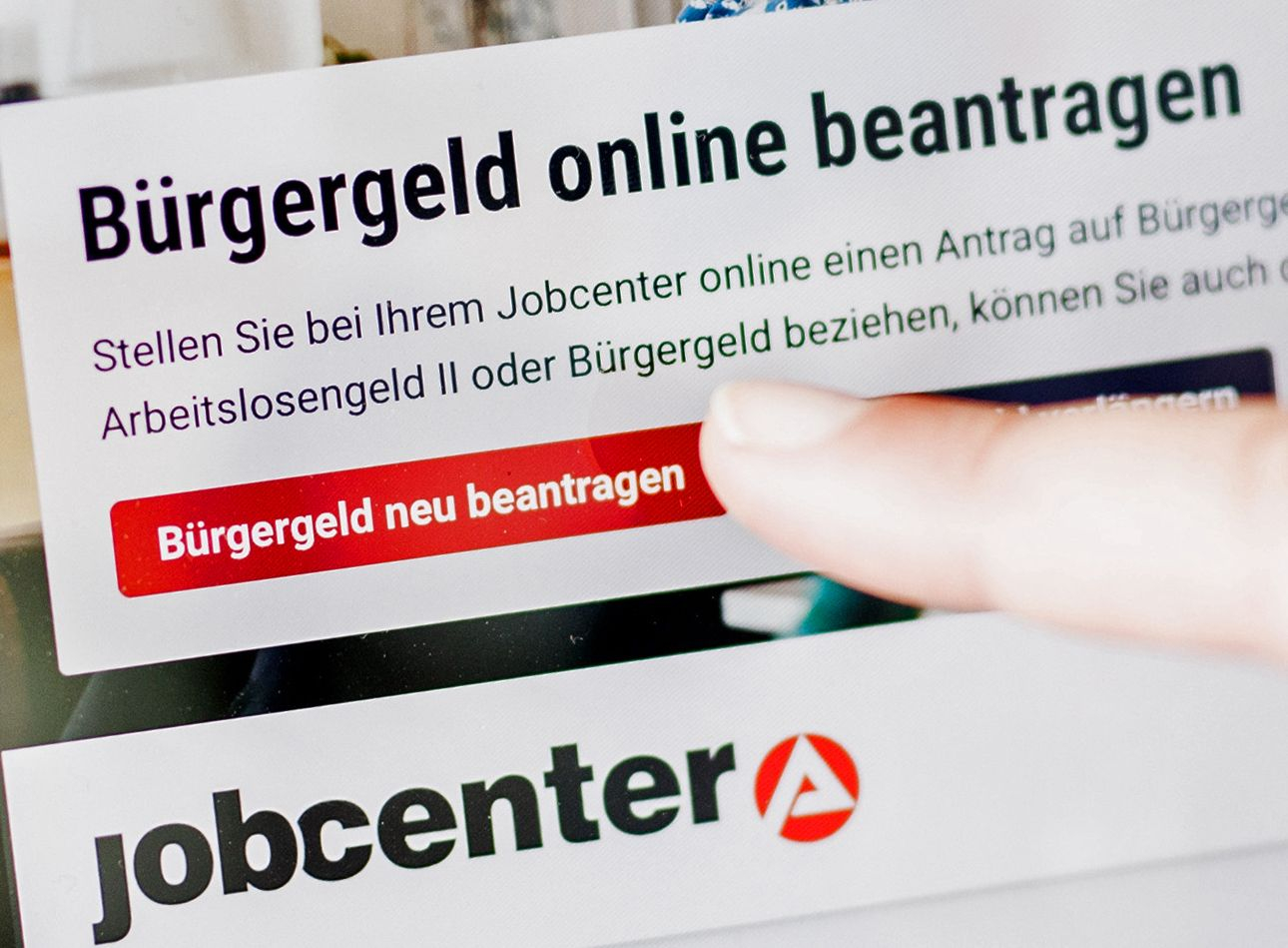 Eine Frau tippt auf einem Tablet auf einen Link zum Beantragen des Bürgergeldes