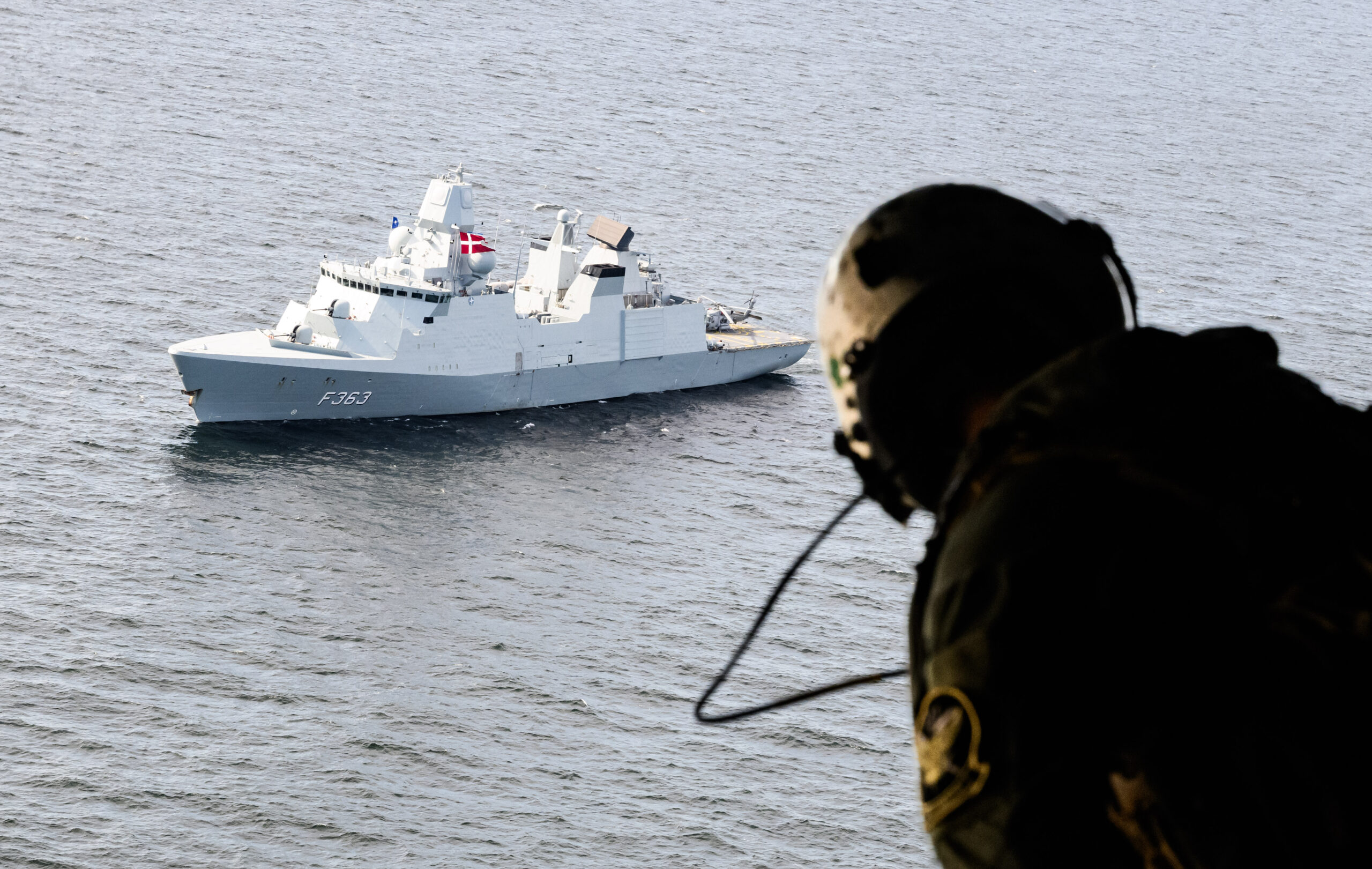 Ein US-Soldat schaut auf ein an einem maritimen Großmanöver beteiligtes Schiff.