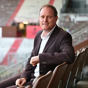 Oke Göttlich posiert auf der Tribüne am Millerntor