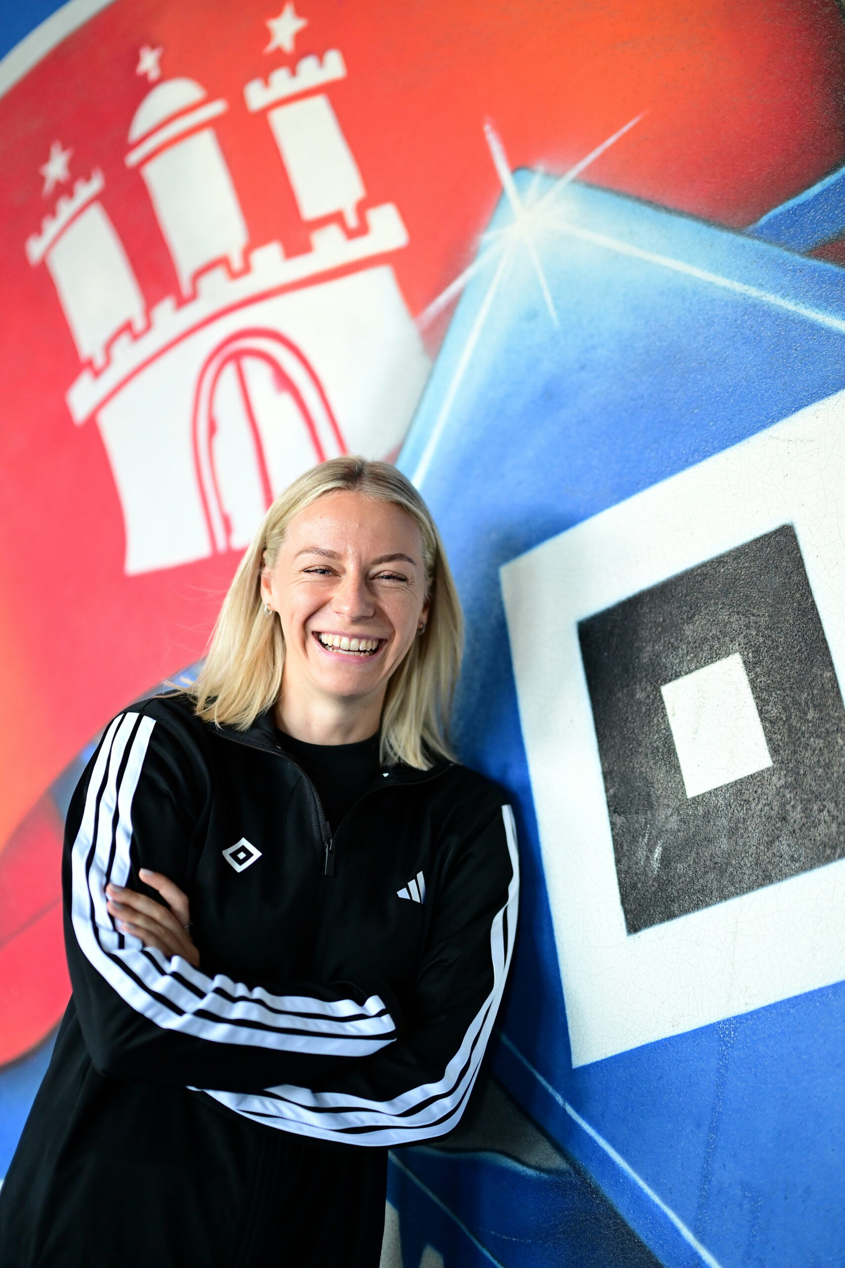 Sophie Hillebrand lehnt an eine HSV-Wand