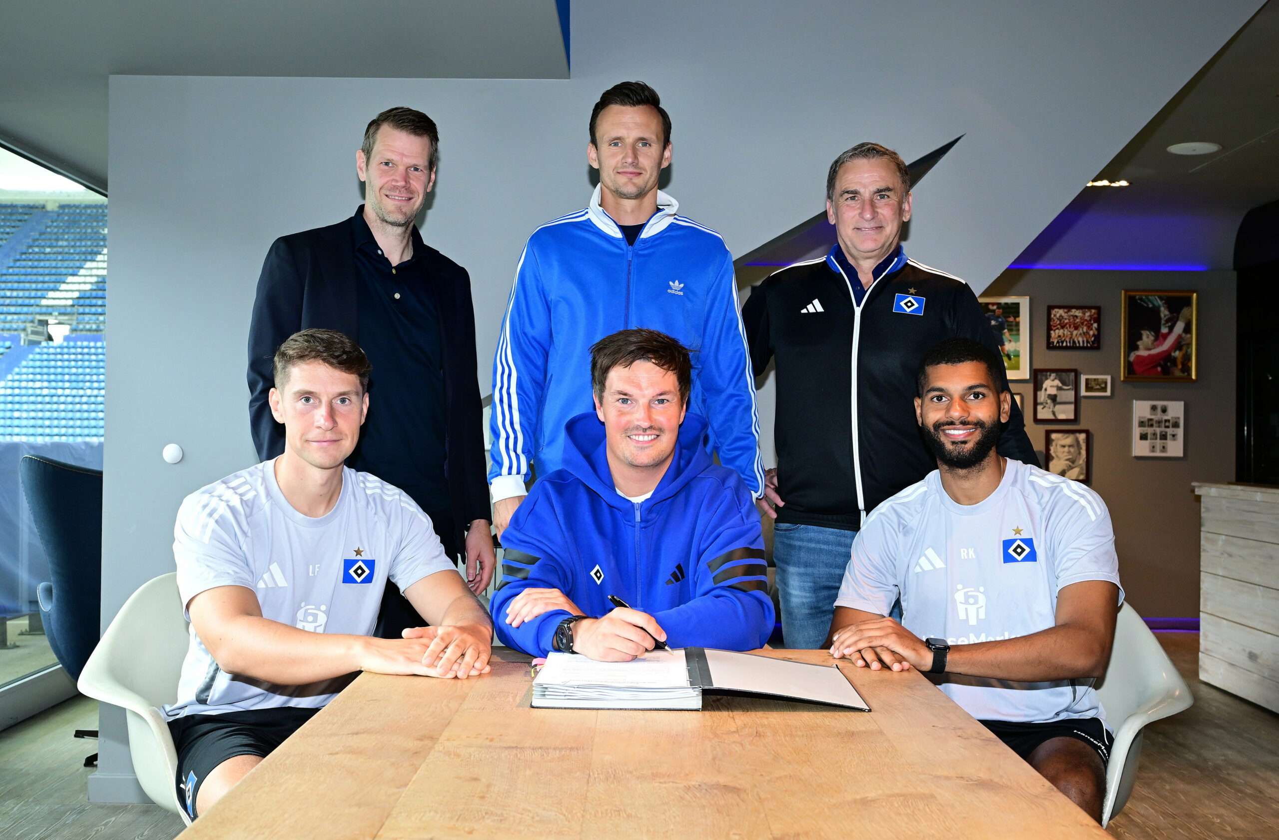 Loic Favé, Merlin Polzin und Richard Krohn sitzen vor Eric Huwer, Claus Costa und Stefan Kuntz am Tisch
