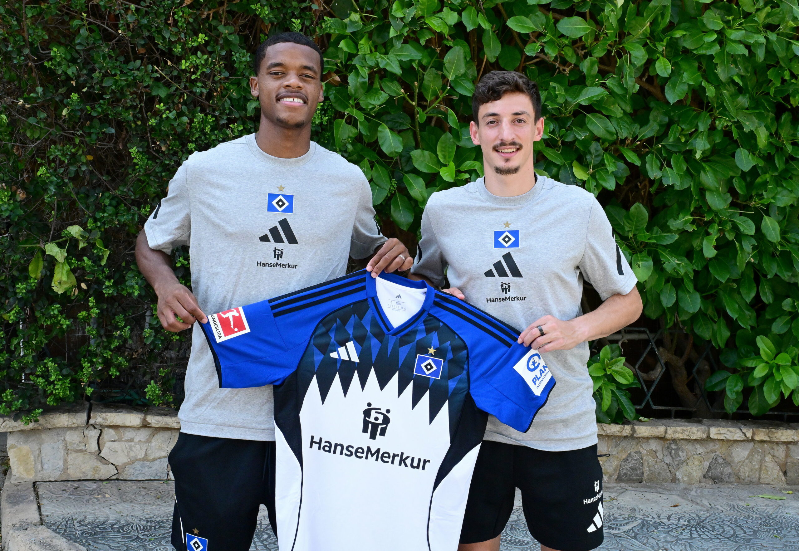 Wared Omari und Giorgi Gocholeishvili halten ein HSV-Trikot hoch