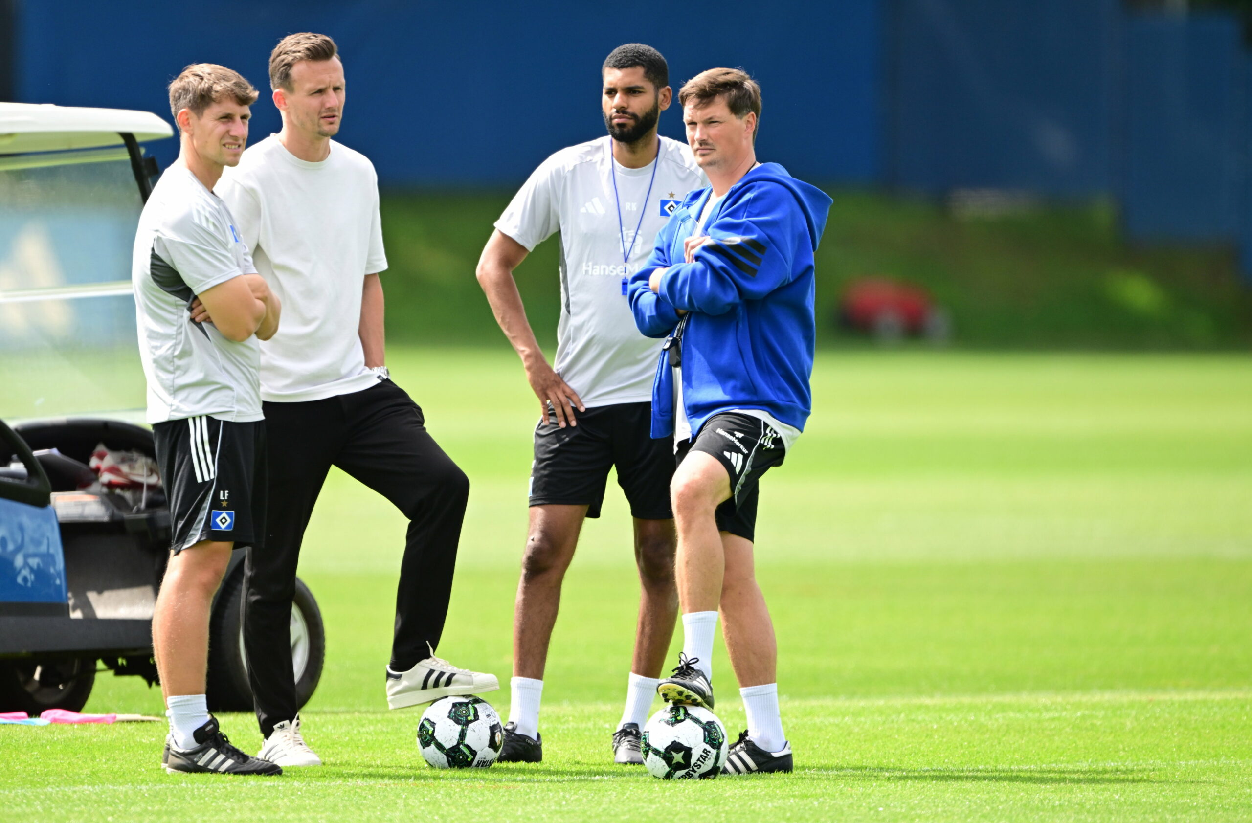 Loic Favé, Claus Costa, Richard Krohn und Merlin Polzin auf dem Trainingsplatz im Gespräch