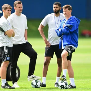 Loic Favé, Claus Costa, Richard Krohn und Merlin Polzin auf dem Trainingsplatz im Gespräch
