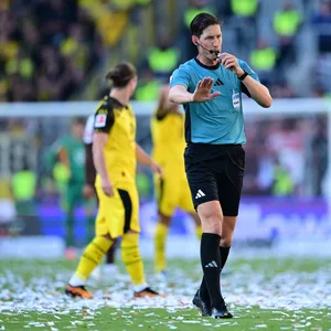 Schiedsrichter Matthias Jöllenbeck auf dem mit Konfetti übersäten Platz.