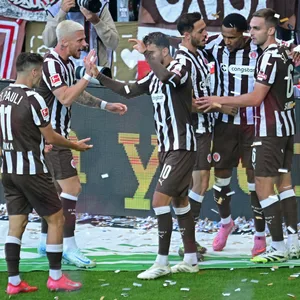 James Sands (r.) jubelt mit Torschütze Andreas Hountondji und weiteren St. Pauli-Profis über das 1:1 gegen Dortmund.