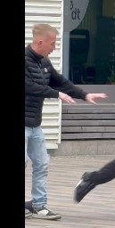 Ein junger Mann in Jeans und schwarzem Oberteil streckt die Arme nach vorne.