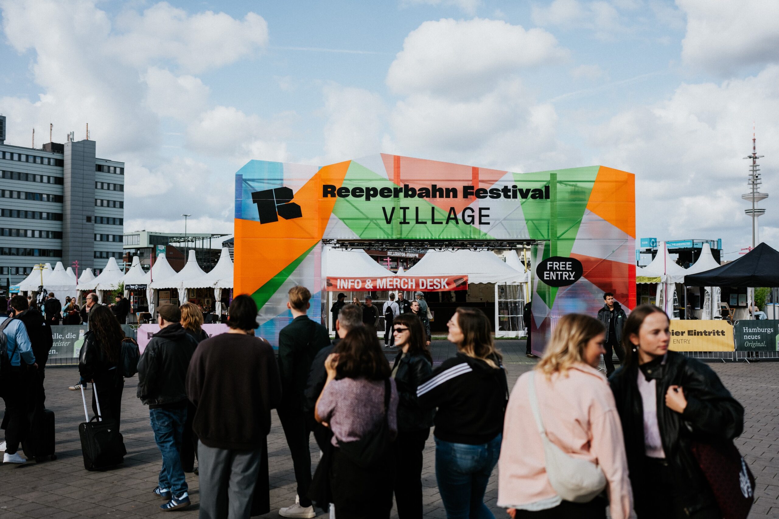 Einfang zum Gelände auf dem Heiligengeistfeld, man kann „Reeperbahn Festival Village, free entry“ lesen, davor stehen Menschen