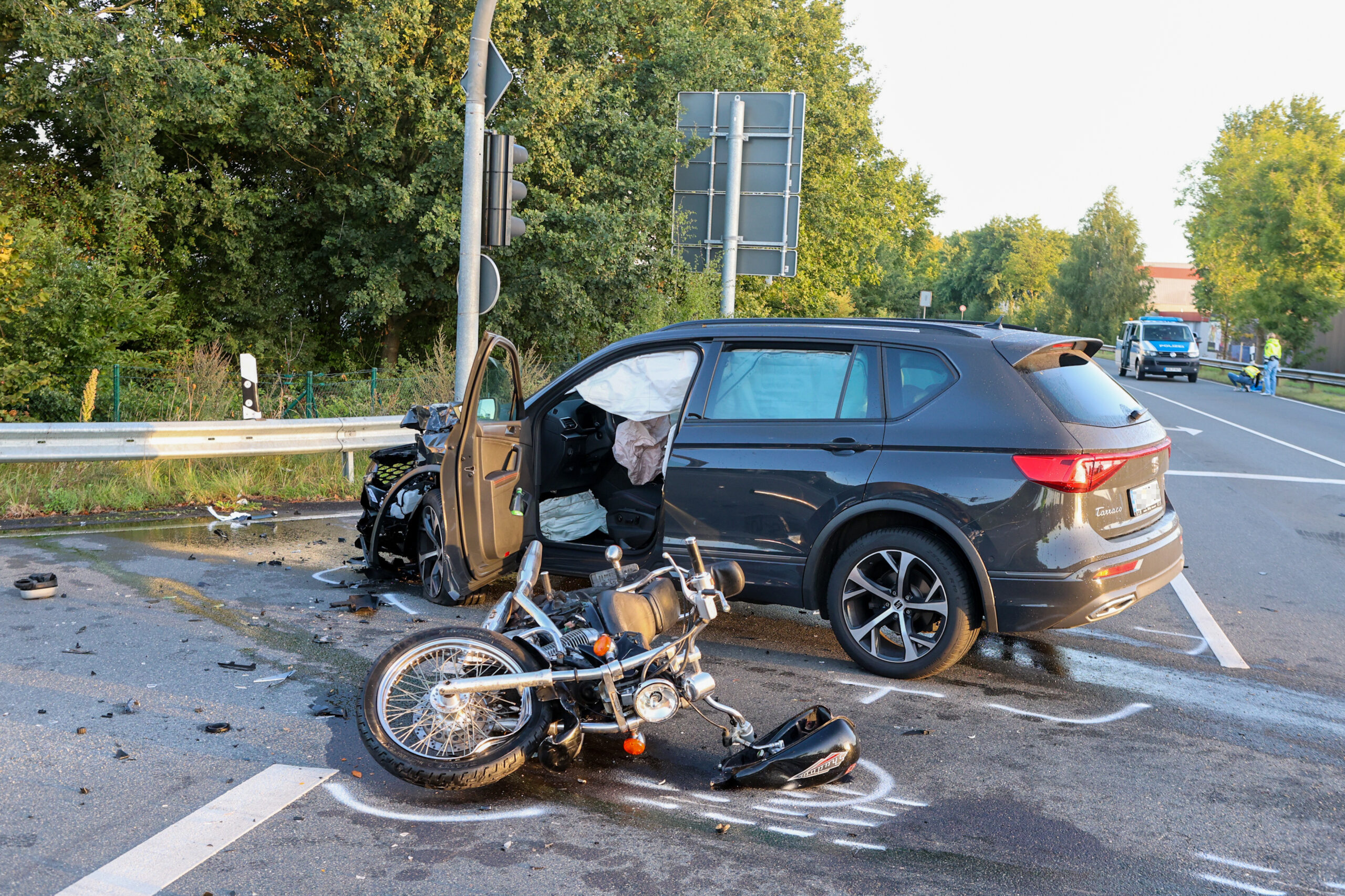 Das beschädigte Motorrad liegt auf der Seite. Daneben steht der Pkw, mit dem es kollidierte.