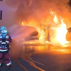 Feuerwehrkräfte setzten zunächst Wasser ein, um die brennenden Fahrzeuge zu löschen.