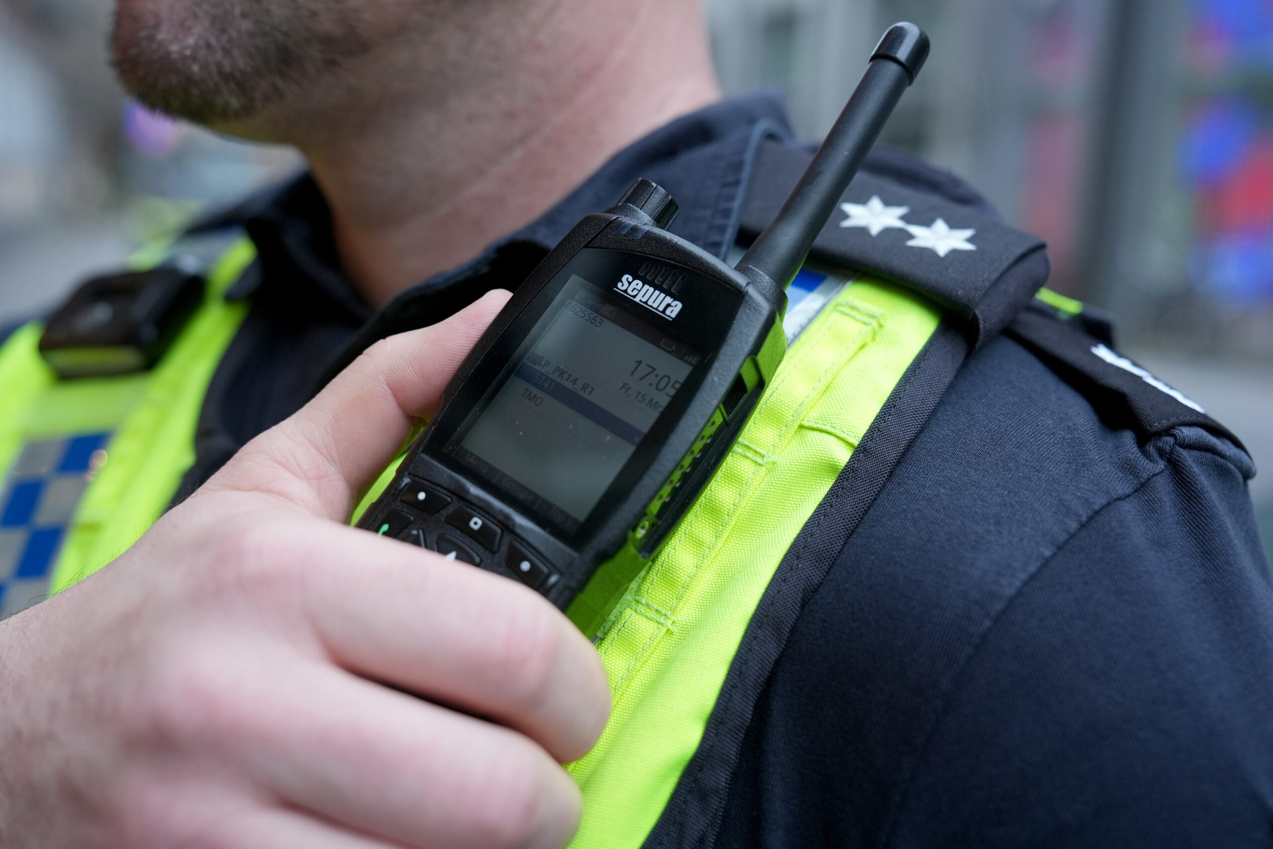 Ein Polizist greift an sein Funkgerät (Symbolbild).