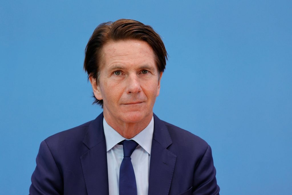Mann in Anzug vor blauem Hintergrund