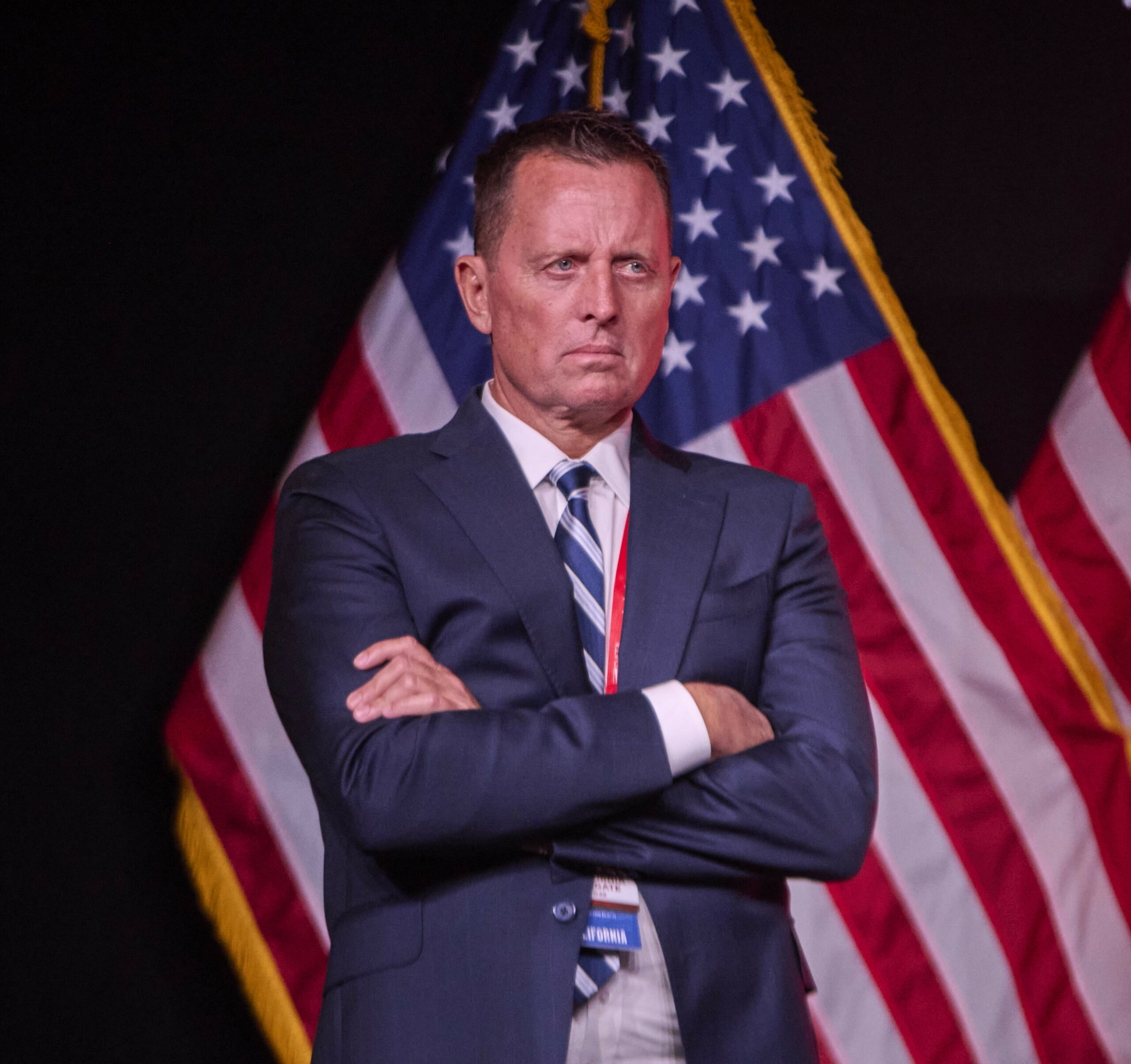 Richard Grenell steht vor einer US-Amerikanischen Flagge