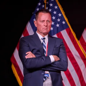 Richard Grenell steht vor einer US-Amerikanischen Flagge