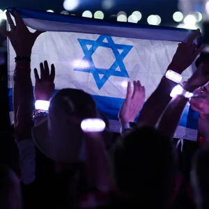 Ein ESC-Besucher hält beim Auftritt der israelischen Sängerin Raphael eine Israel-Flagge in die Höhe.