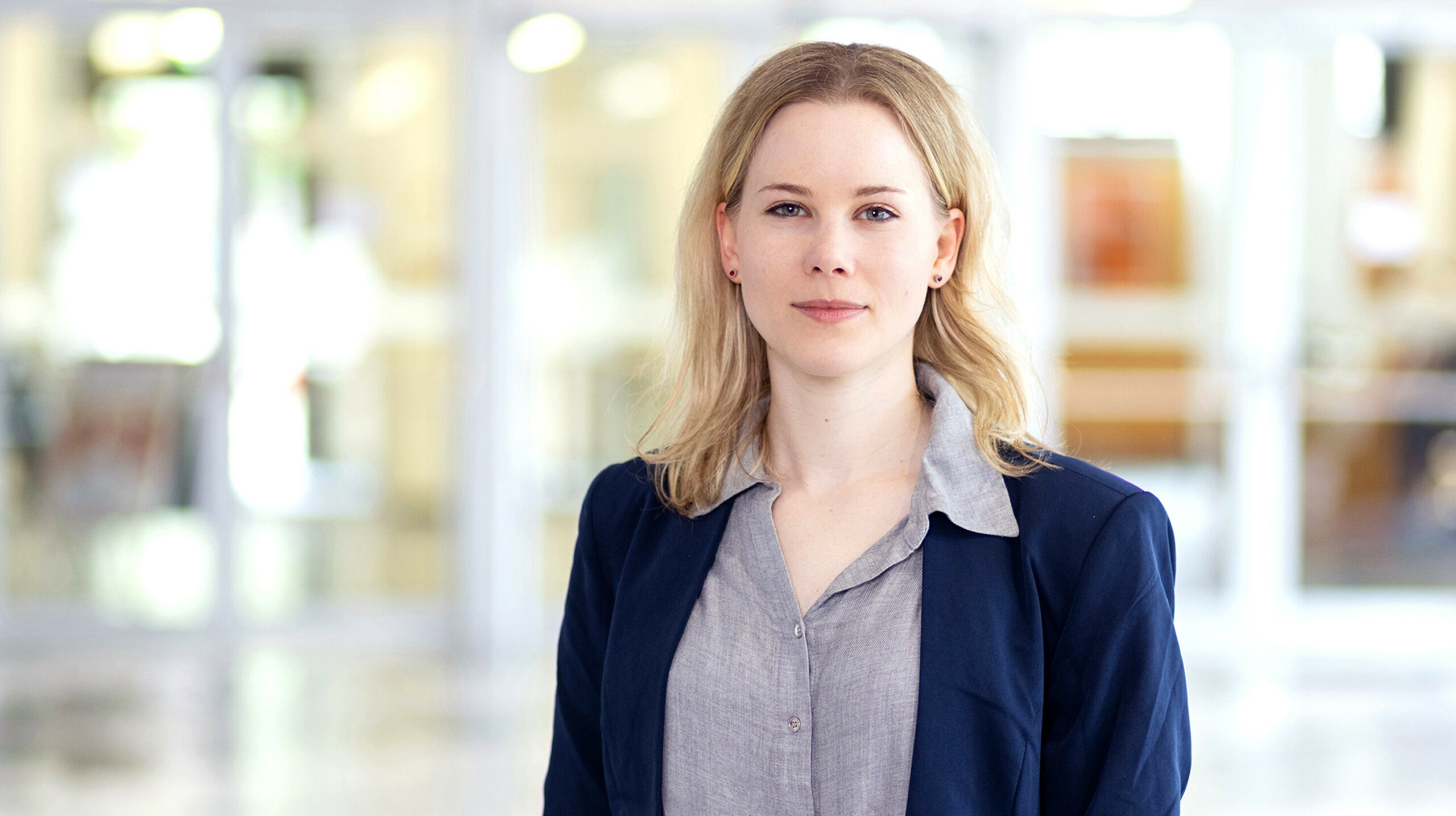 Junge blonde Frau in blauem Blazer