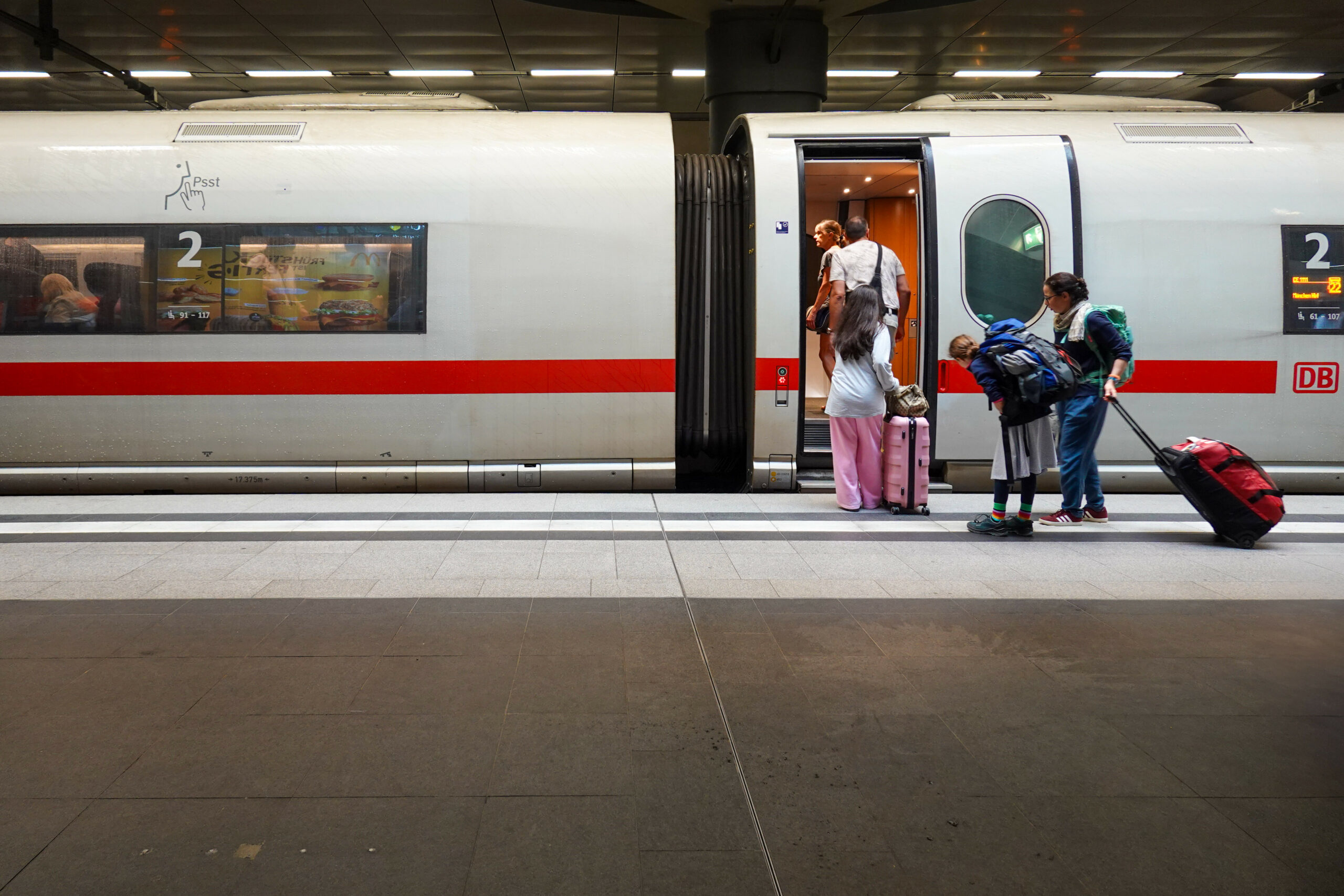Reisende im ICE der Deutschen Bahn stehen auf den Bahnsteigen des Berliner Hauptbahnhofs in Berlin, Deutschland..