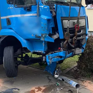 Ein stark beschädigter, blau-beiger Lastwagen wird von der Unfallstelle abtransportiert.