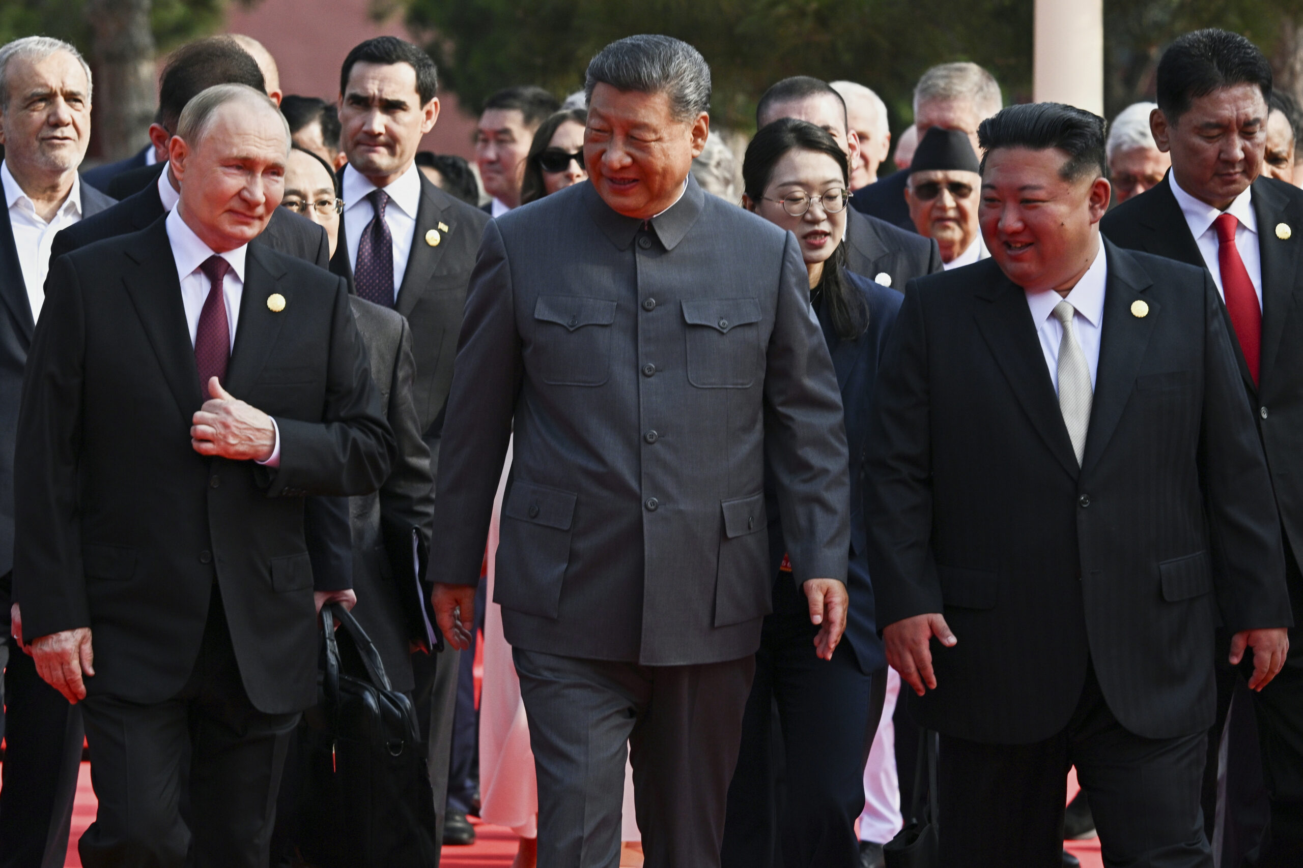 Der russische Präsident Wladimir Putin, der chinesische Präsident Xi Jinping und der nordkoreanische Machthaber Kim Jong Un laufen nebeneinander.