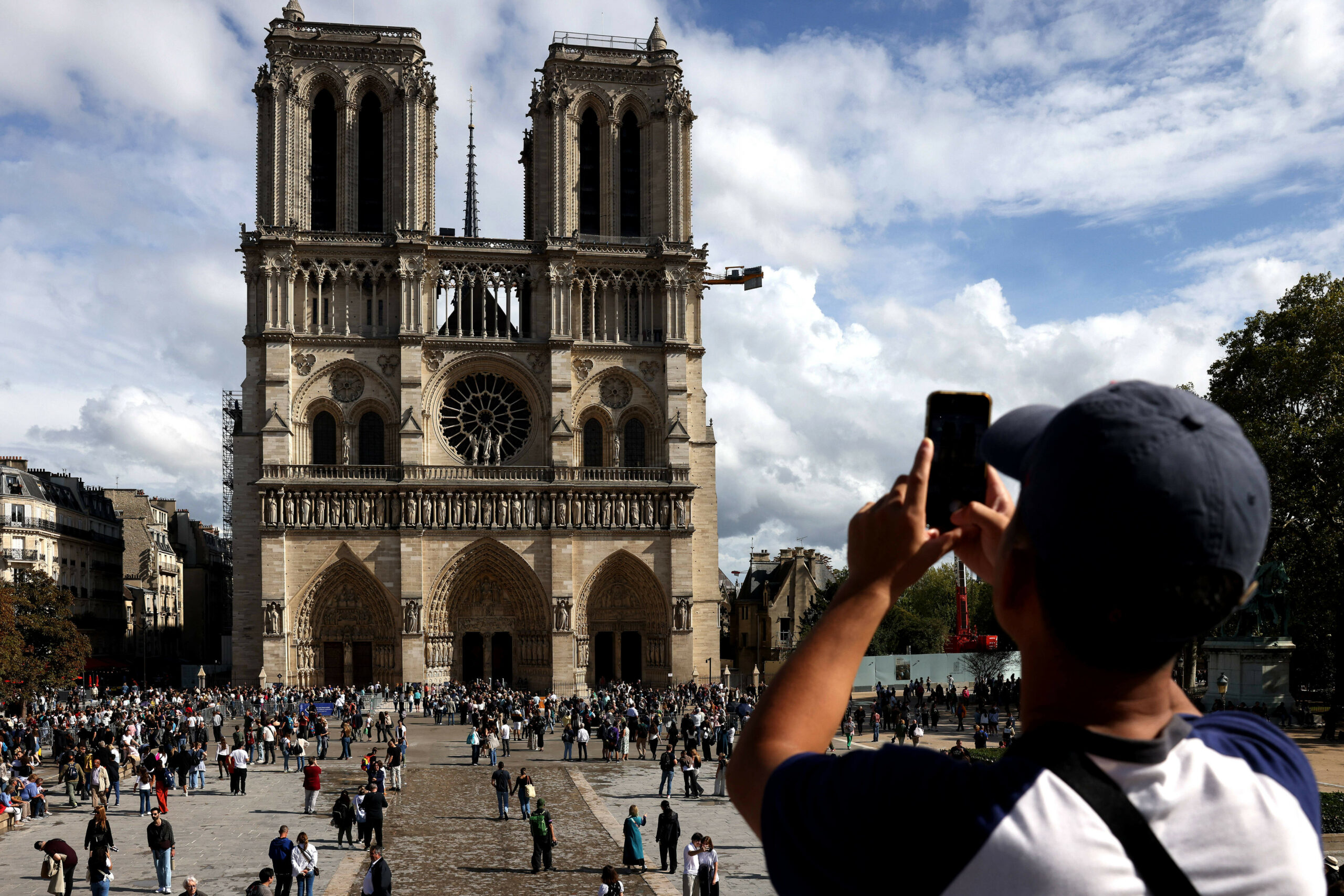 Ein Mann macht ein Bild von der Kathedrale Notre-Dame in Paris.