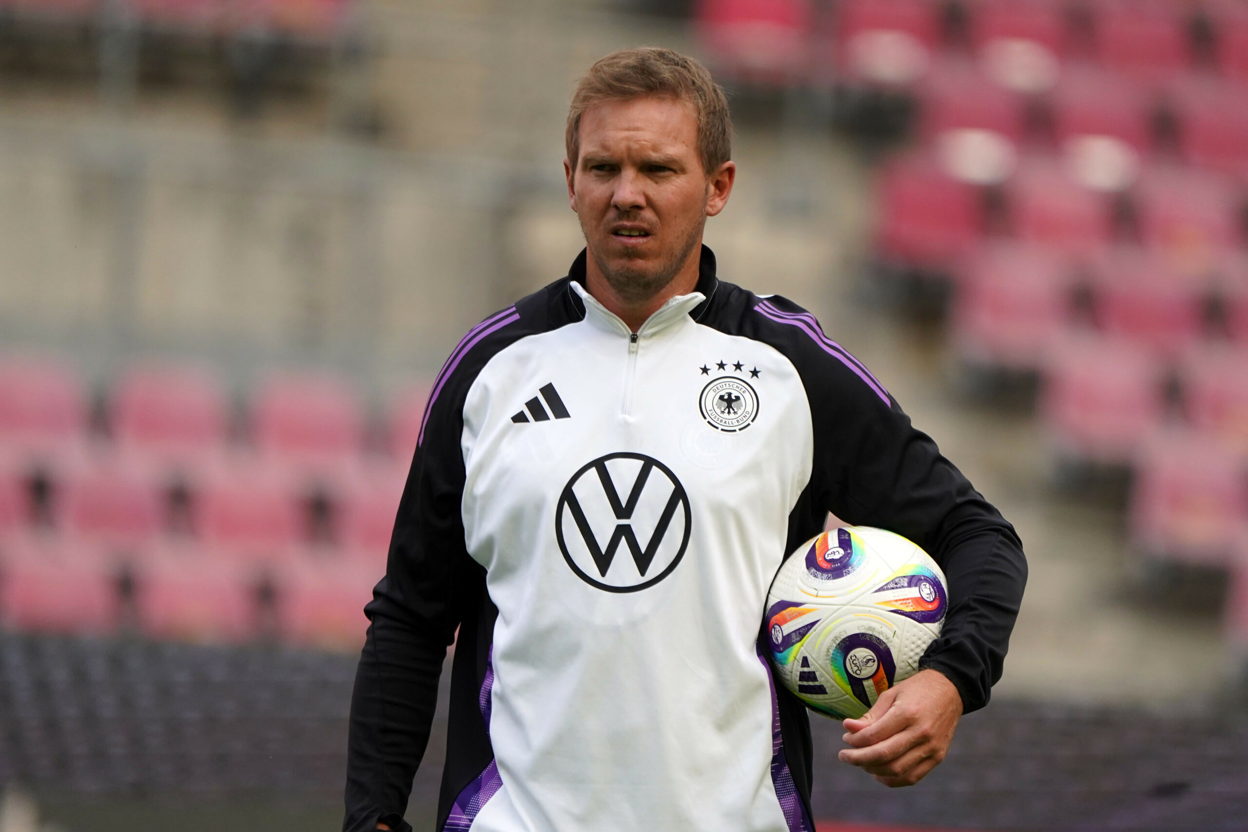 Julian Nagelsmann hält einen Ball im Arm