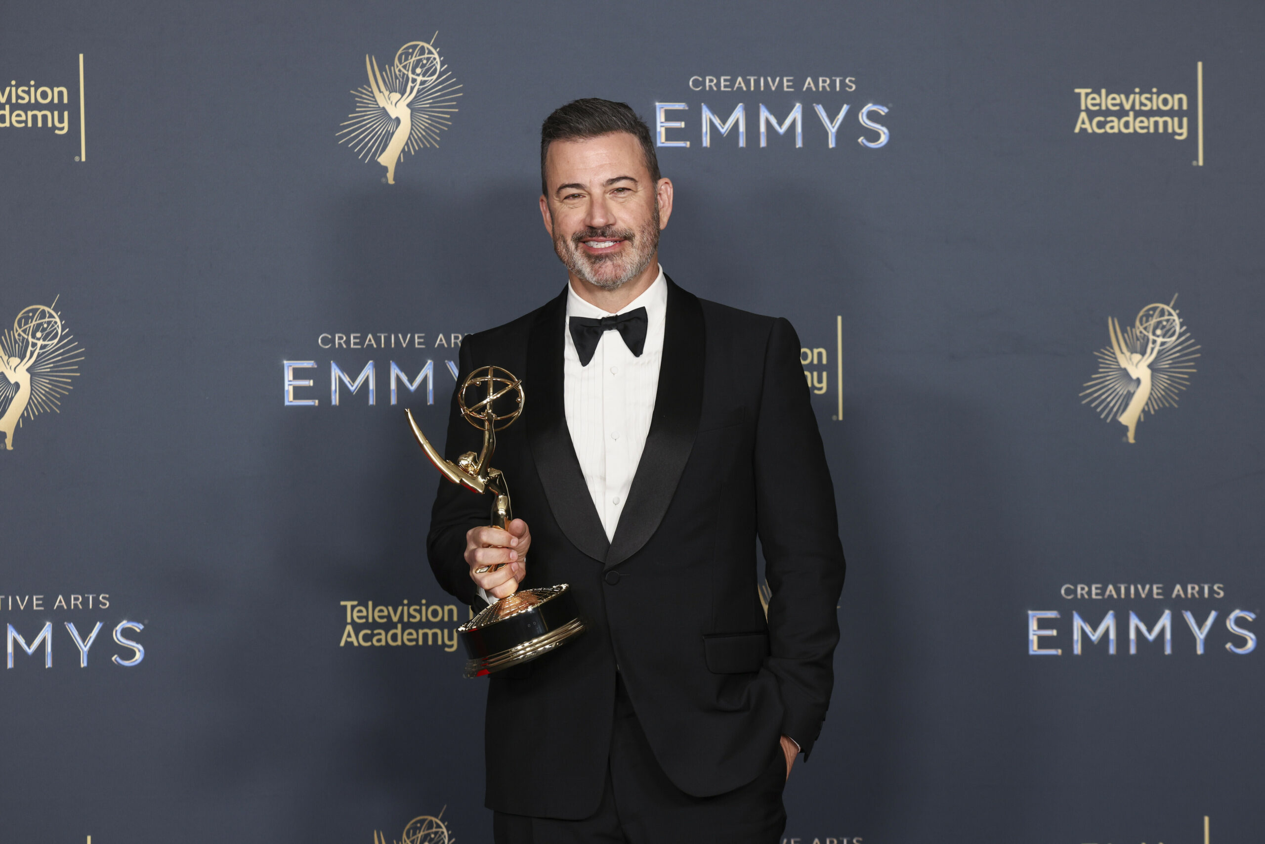 Mann im Anzug mit einem Emmy-Preis in der Hand