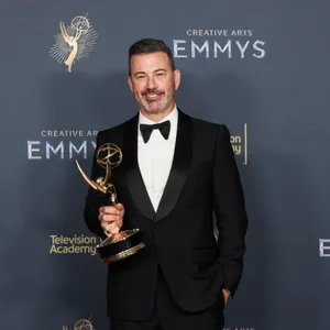 Mann im Anzug mit einem Emmy-Preis in der Hand