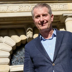 Mann in Jacket vor Gerichtsgebäude