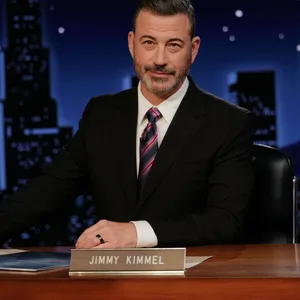 Jimmy Kimmel sitzt in seiner Show hinter dem Schreibtisch in seinem Studio.